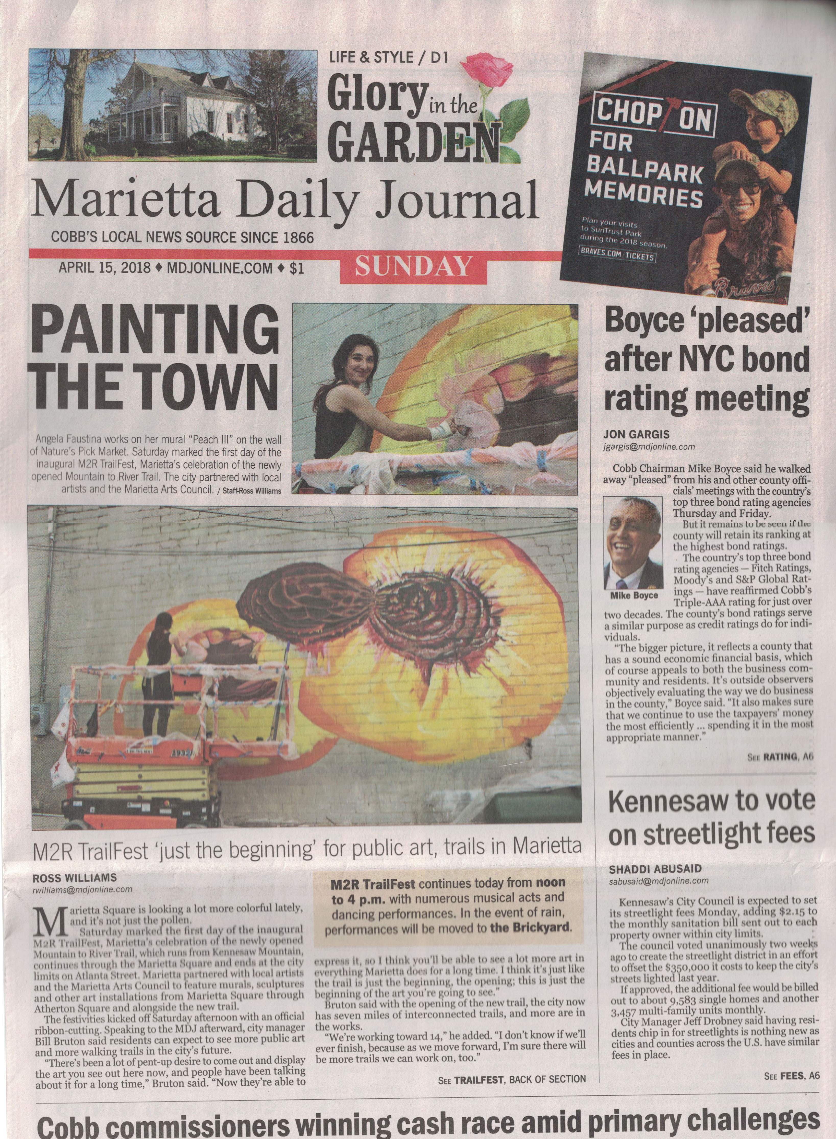 Marietta Daily Journal front page news article about Angela Faustina painting Peach III mural on Marietta Square for the M2R Trailfest, sponsored by Nature's Pick Market.